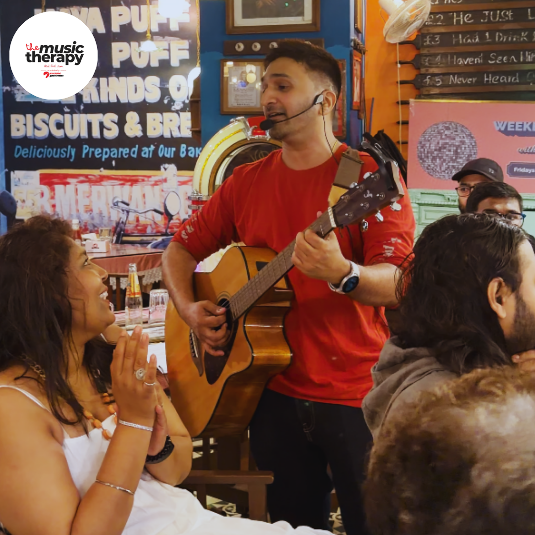 Guitarist performing for guests at a Music Therapy cafe session