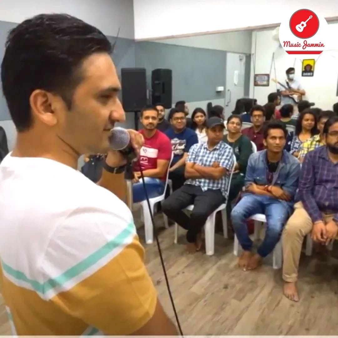 Artist addressing a seated audience at a Music Jammin session