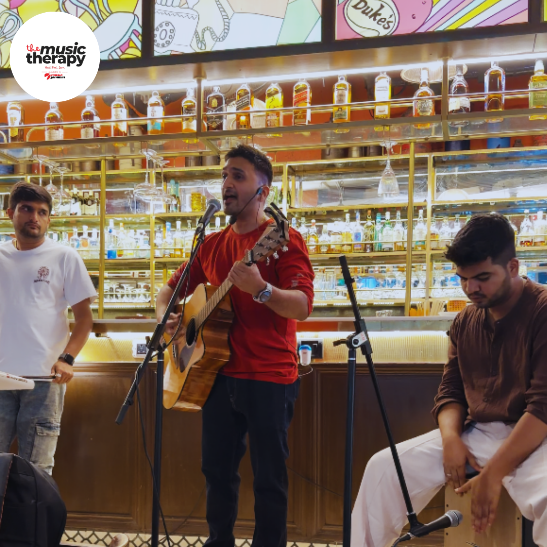 Singer with guitar and cajon player at a Music Therapy performance